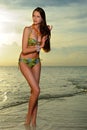 Model in bikini with coral necklace posing on the empty beach Royalty Free Stock Photo