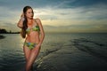 Model in bikini with coral necklace posing on the empty beach Royalty Free Stock Photo