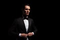 Model in black tux with bowtie posing in dark studio