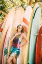 Model in a bright dress. Surf background. Hand on a hip