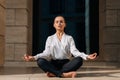 Model business young woman in a stylish elegant suit sitting in a namaste pose. Beautiful brunette girl in a fashionable glamorous Royalty Free Stock Photo