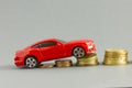 Model of car on background of coins, concept of car loan, car insurance