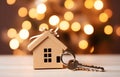 Model of cardboard house with key against bokeh background. house building, loan, real estate or buying a new home Royalty Free Stock Photo