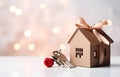 Model of cardboard house with key against bokeh background. house building, loan, real estate or buying a new home Royalty Free Stock Photo