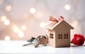 Model of cardboard house with key against bokeh background. house building, loan, real estate or buying a new home Royalty Free Stock Photo