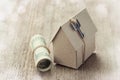 Model of cardboard house with key and dollar bills. House building, loan, real estate, cost of housing or buying a new home concep Royalty Free Stock Photo