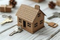 A model of a cardboard house on a table with a key