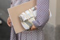 Model carries a white and golden purse in her hand