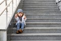 Model child hip-hop sitting on stairs outdoor.girl child street fashion jeans clothes