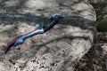 Model of daedric dagger from The Elder Scrolls: Skyrim lying on large rough stone slab Royalty Free Stock Photo