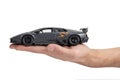 Model of a dark sports car in hand on a white background Royalty Free Stock Photo