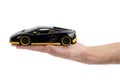 Model of a dark sports car in hand on a white background Royalty Free Stock Photo