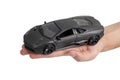 Model of a dark sports car in hand on a white background Royalty Free Stock Photo