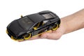 Model of a dark sports car in hand on a white background Royalty Free Stock Photo