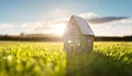 Model detatched cottage house in empty field at sunset background concept for construction and real estate Royalty Free Stock Photo