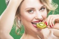 Model With Disheveled Hair Biting Slice of Green Juicy Kiwi Fruit Royalty Free Stock Photo