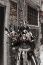 A model dressed in carnival costume of pagan witch with the sculls, furs and feathers on it in Venice, Italy, old style sepia