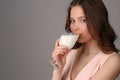 Model drinking milk from a bocal. Close up. Gray background