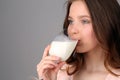 Model drinking milk from a wine glass. Close up. Gray background