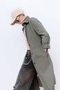 Model in fashion urban street outfit. Trendy cap and military coat. Stylish Fall winter seasons. Casual look book