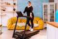 Model - a fat woman, trying to lose weight and at home engaged on a treadmill