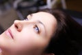 Model girl with blue eyes is lying on a permanent makeup procedure her eyebrows are being prepared for powder spraying