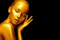 Model girl with shiny golden professional makeup over black. Beauty sexy woman with golden skin. Fashion art portrait closeup Royalty Free Stock Photo