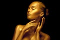 Model girl with shiny golden professional makeup over black. Beauty sexy woman with golden skin. Fashion art portrait closeup Royalty Free Stock Photo