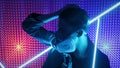 A model guy is dancing in a neon studio in a gas mask. Concept in dubstep style. Air pollution and global warming. Rave