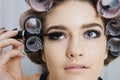 Model In Hair Curlers Applying Mascara Royalty Free Stock Photo