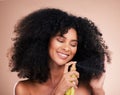 Model, happy or afro hair spray on isolated studio background in frizz control, curly management or oil treatment. Black