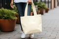 Model hold blank white fabric mockup bag for save environment on street fashion