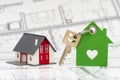 Model home with key standing on construction plan Royalty Free Stock Photo