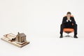 Model home on mouse trap with worried businessman sitting on chair representing increasing real estate rates Royalty Free Stock Photo