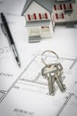 Model Home, Pencil and Keys Resting On House Plans Royalty Free Stock Photo
