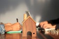 Model house and businessman signing documents on the table, New home and ownership property concept Royalty Free Stock Photo