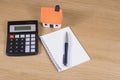 Model house, calculator and notebook with pen Royalty Free Stock Photo