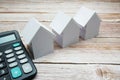 Model House and calculator on wooden background, realestate concept