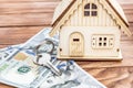 Model of house with dollar bills and key on wooden background Royalty Free Stock Photo