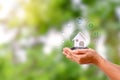 Model house with energy icon in a human hand, energy-saving