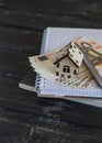 Model house, Euro banknotes, notepad on dark wooden background. Royalty Free Stock Photo