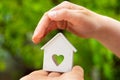 Model of house with heart window stand on child hand Royalty Free Stock Photo