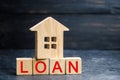 Model of the house and the inscription `Loan`. Buying a home in debt. Family investment in real estate and risk management concept Royalty Free Stock Photo