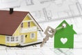 Model house with key standing on architectural plan Royalty Free Stock Photo
