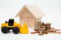 Model house, loader, coins stack on white background for money saving concept