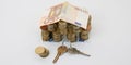 model house made from Euro banknotes and coins with home keys on the white table Royalty Free Stock Photo