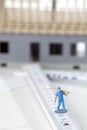 Model house with miniature handwerker figurines standing on folding ruler in foreground Royalty Free Stock Photo