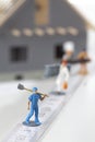 Model house with miniature handwerker figurines standing on folding ruler in foreground Royalty Free Stock Photo