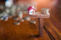 Model house and money coins balancing on a seesaw, Property real Royalty Free Stock Photo