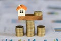 Model house and money coins balancing on a seesaw, Property real estate investment ideas, Concept of risk house mortgage, loan Royalty Free Stock Photo